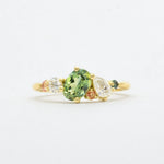 asymmetric engagement ring in lightbox with green and pink sapphires and lab-grown diamonds