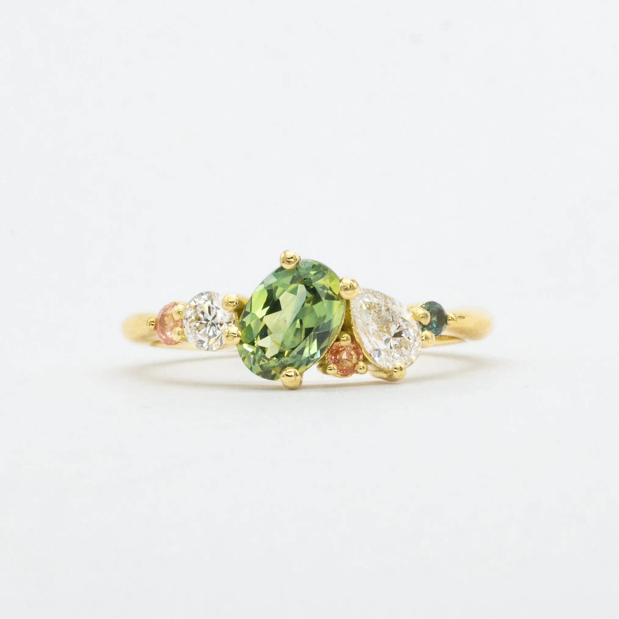 asymmetric engagement ring in lightbox with green and pink sapphires and lab-grown diamonds