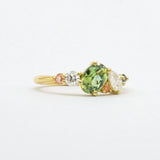 side angle of engagement ring featuring large green sapphire, pink sapphires and diamonds