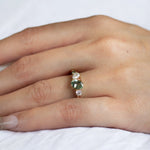 close up of hand wearing pink and green sapphire engagement ring with lab-grown diamonds