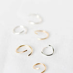 Set of gold and silver hoop cartilage earrings on a white background