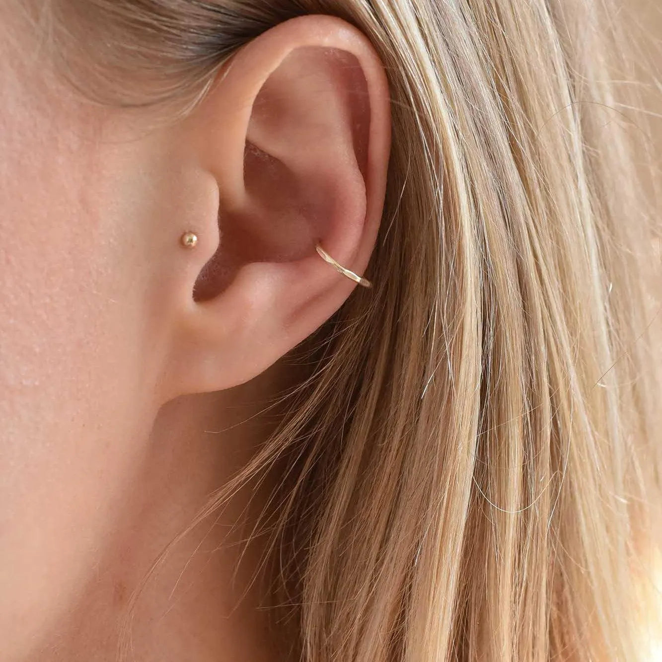 models ear wearing solid gold conch hoop and tragus stud