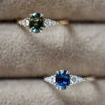 Two rings with blue and green sapphires on a textured surface