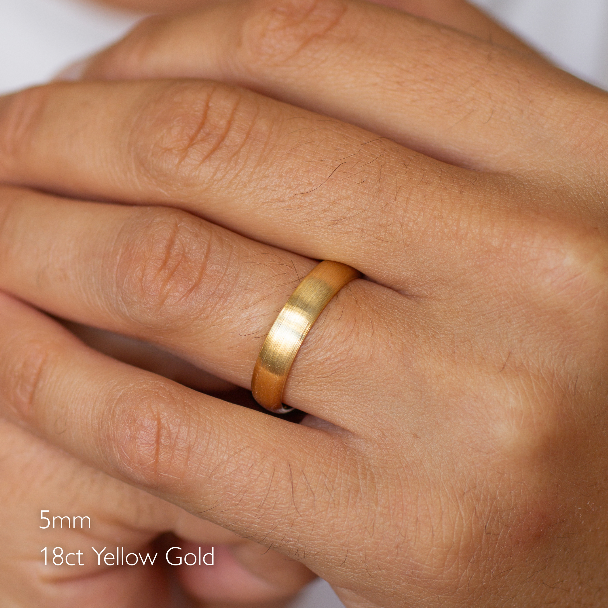 male hand wearing d shaped gold wedding ring in 5mm width and 18ct yellow gold