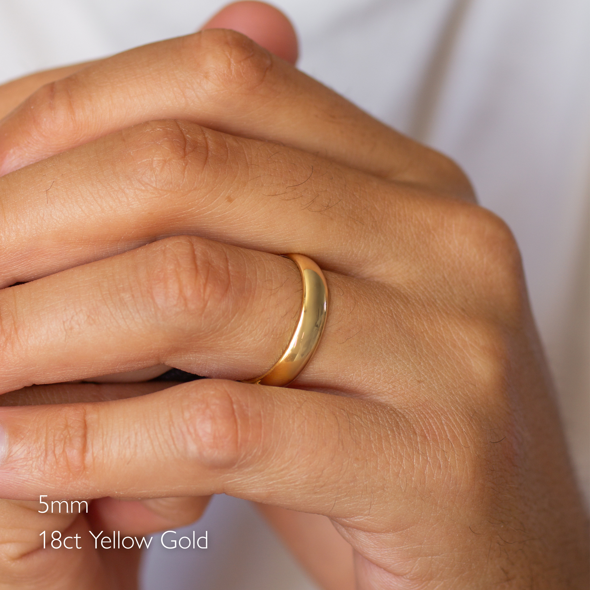 Gold ring on a hand with '5mm 18ct Yellow Gold' text