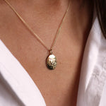 Close up of model wearing solid gold taurus necklace