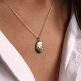 Close up of model wearing solid gold taurus necklace