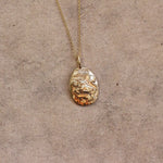 Close up of solid gold taurus necklace pendant