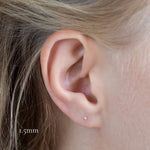 close up of ear wearing yellow gold solitaire diamond studs in 1.5mm