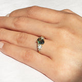 Close up of hand wearing Asymmetric Blue/Green Sapphire and Diamond Engagement Ring