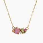 Gold necklace with pink and green sapphires on a white background
