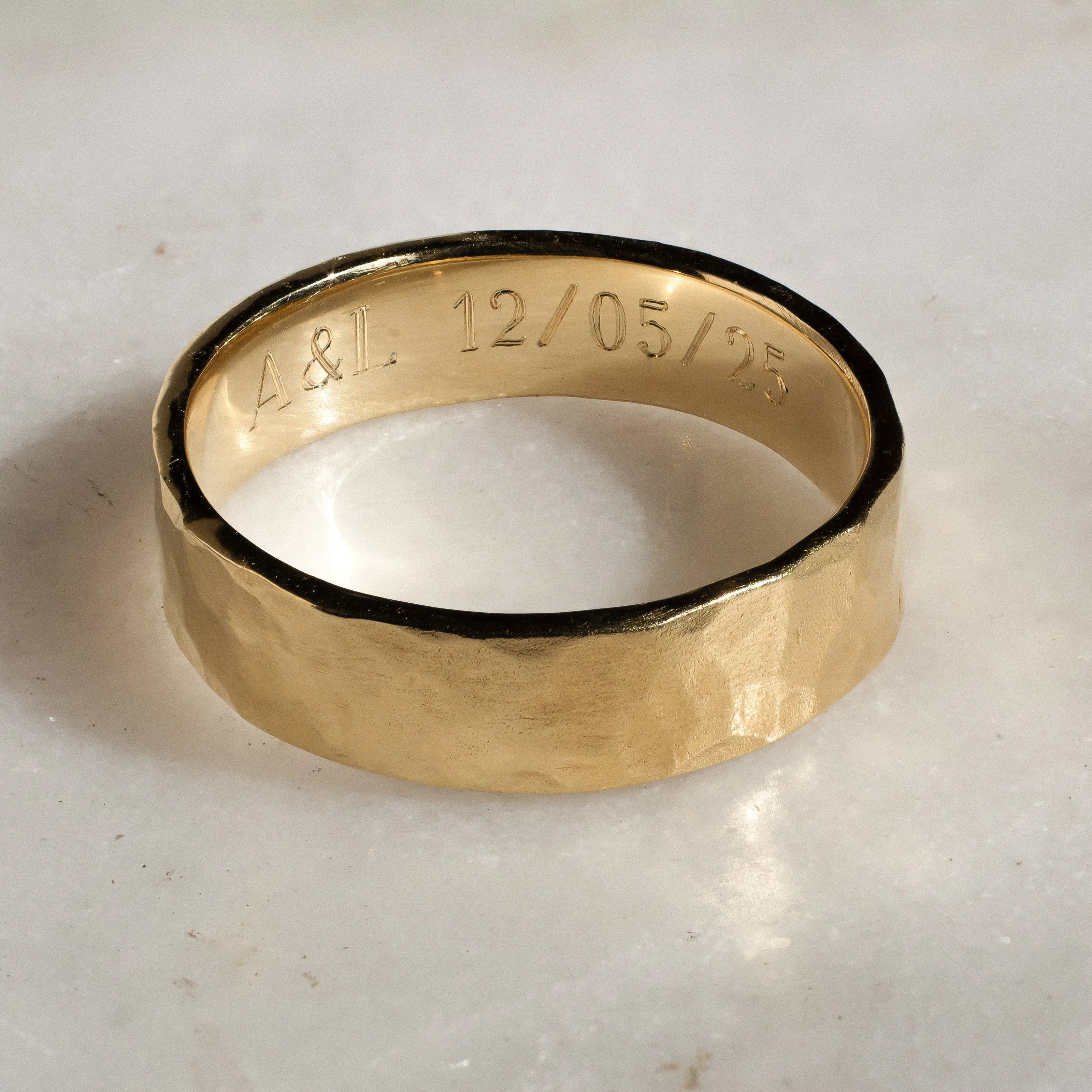 Gold ring with engraved text on a light background