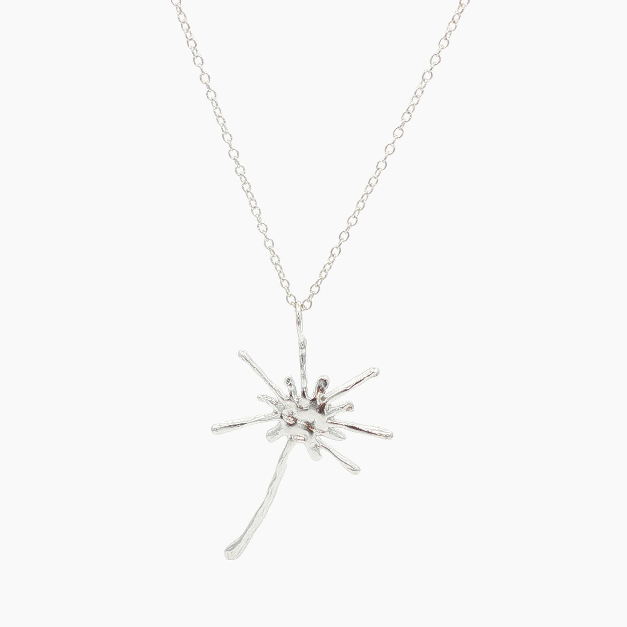Silver starburst dandelion pendant necklace on a white background