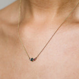 close up of green and pink sapphire necklace being worn