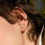 close up of ear wearing lucky gold ear cuff and diamond stud earrings