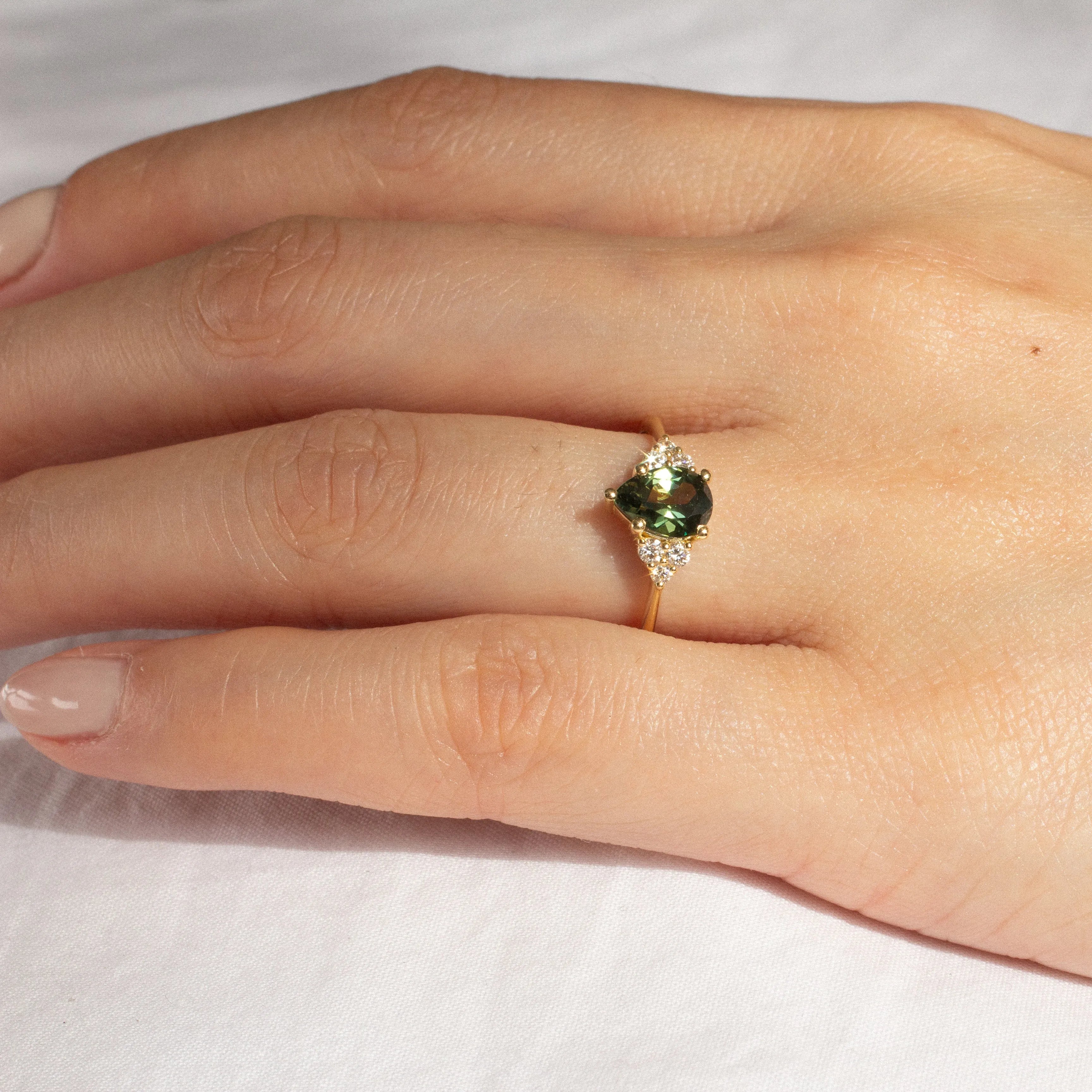 Green Pear Sapphire With Diamond Cluster Detail Engagement Ring
