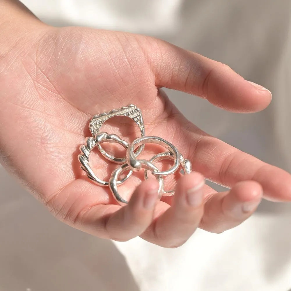 Hand holding silver rings made at the Wild Fawn jewellery workshop in London