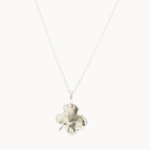 Back of silver necklace with a polished clover-shaped pendant on a white background