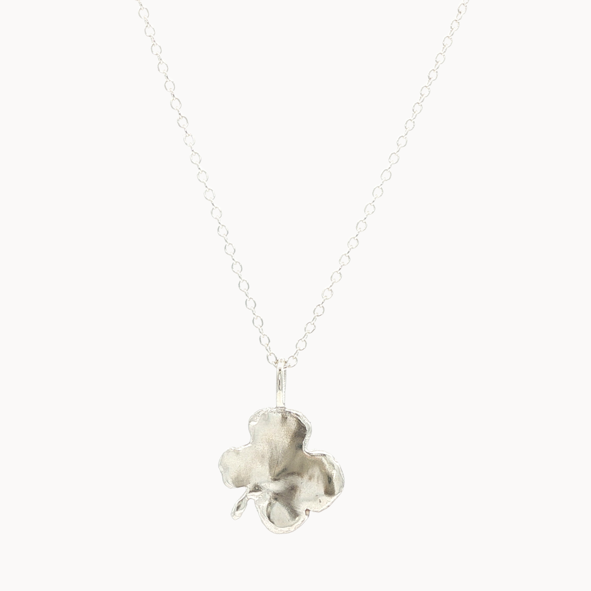 Back of silver necklace with a polished clover-shaped pendant on a white background