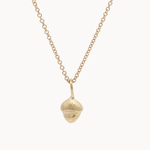 Gold necklace with a small acorn pendant on a white background