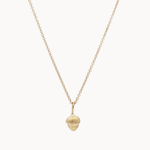 Gold necklace with a small acorn pendant on a white background