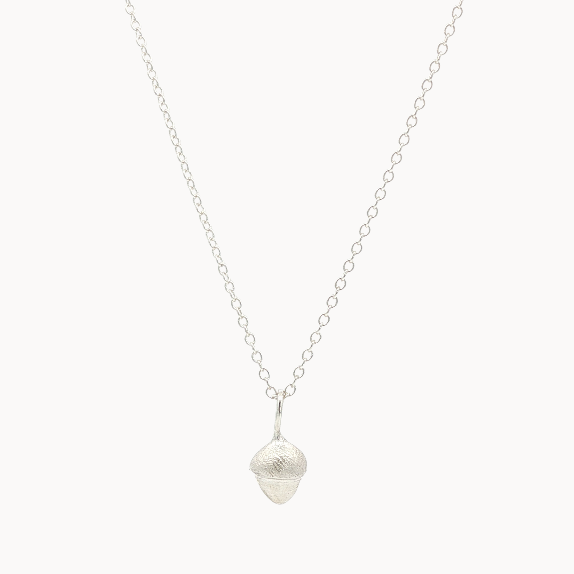 Silver necklace with a small acorn-shaped pendant on a white background