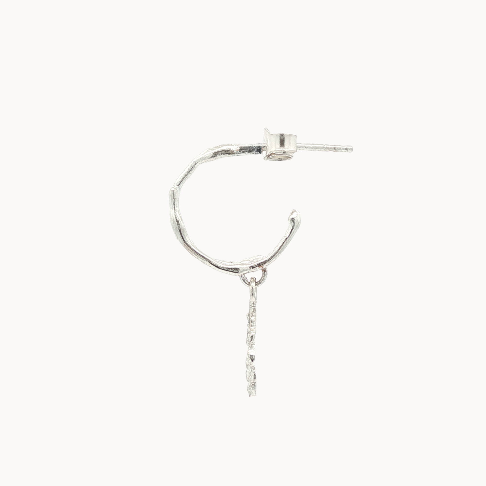 side view of a silver hoop earring with a drop detail on a white background