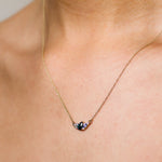 Necklace with a pendant on a person's neck against a neutral background