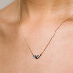 Necklace with a pendant on a person's neck against a neutral background