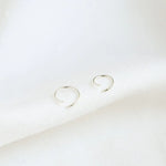 silver small helix hoops open on white surface