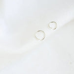 Pair of silver helix hoop earrings on a white background