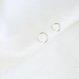 Pair of silver helix hoop earrings on a white background