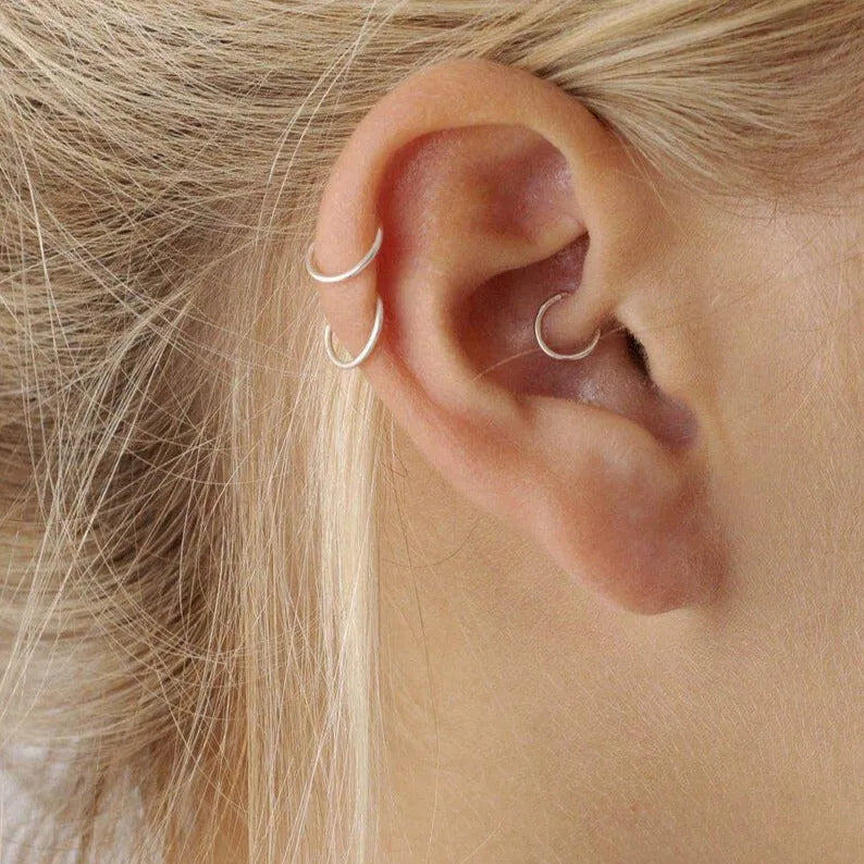 model wearing small helix hoop and cartilage hoop earrings