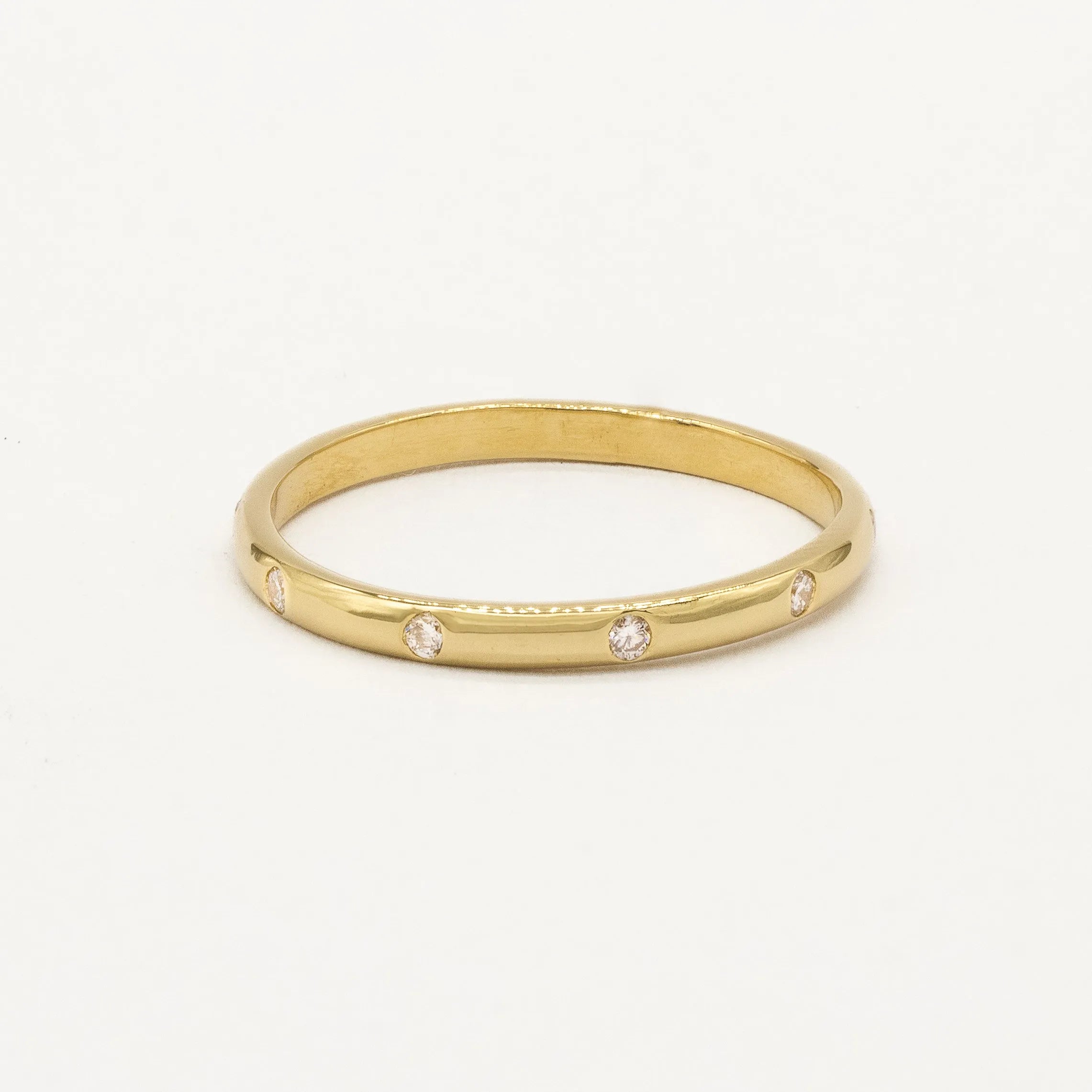 Gold ring with small diamonds on a white background