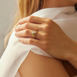 Close up of model wearing Statement Bezel Set Pear Diamond Engagement Ring and Chevron nesting wedding ring in gold