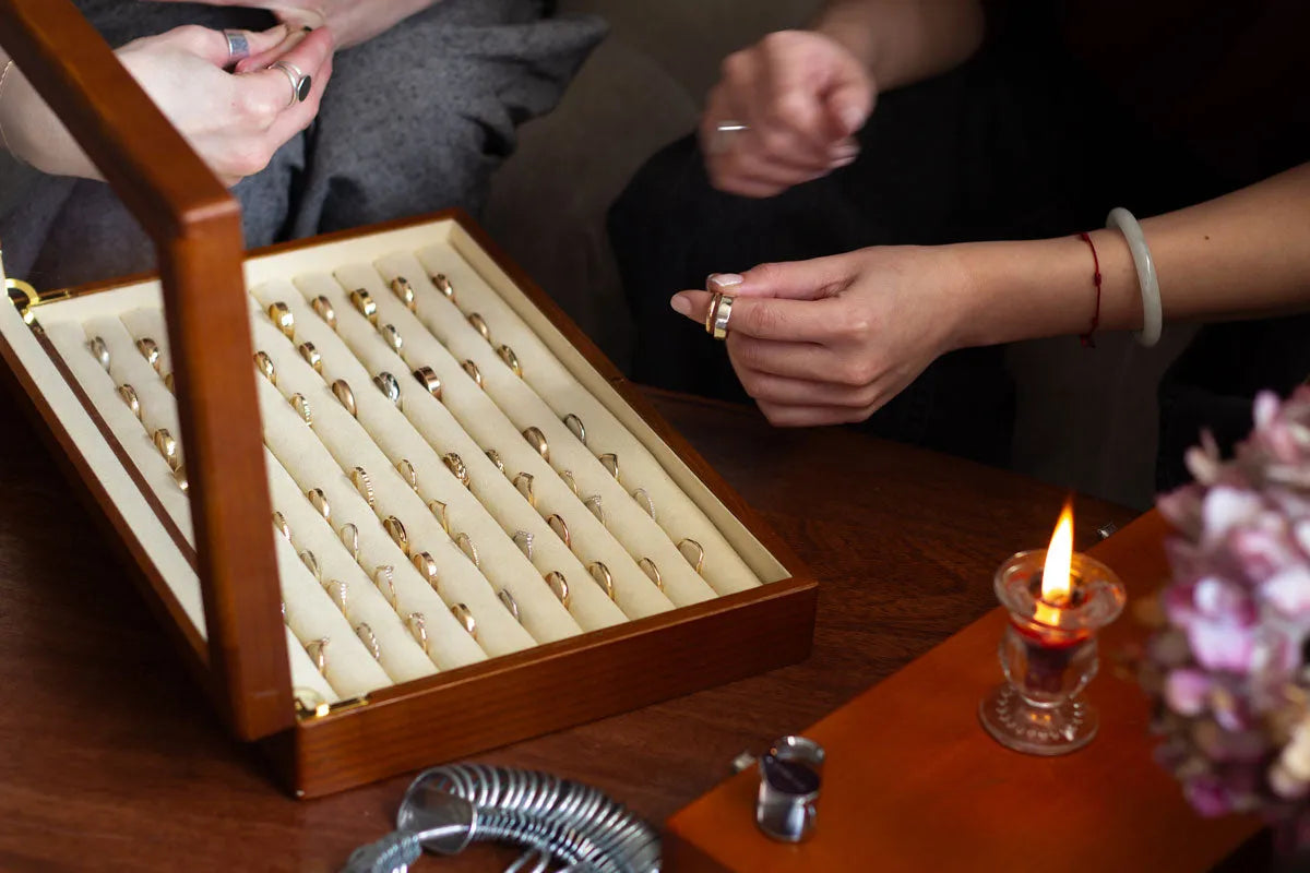 couple sitting infront of wedding ring box trying them on