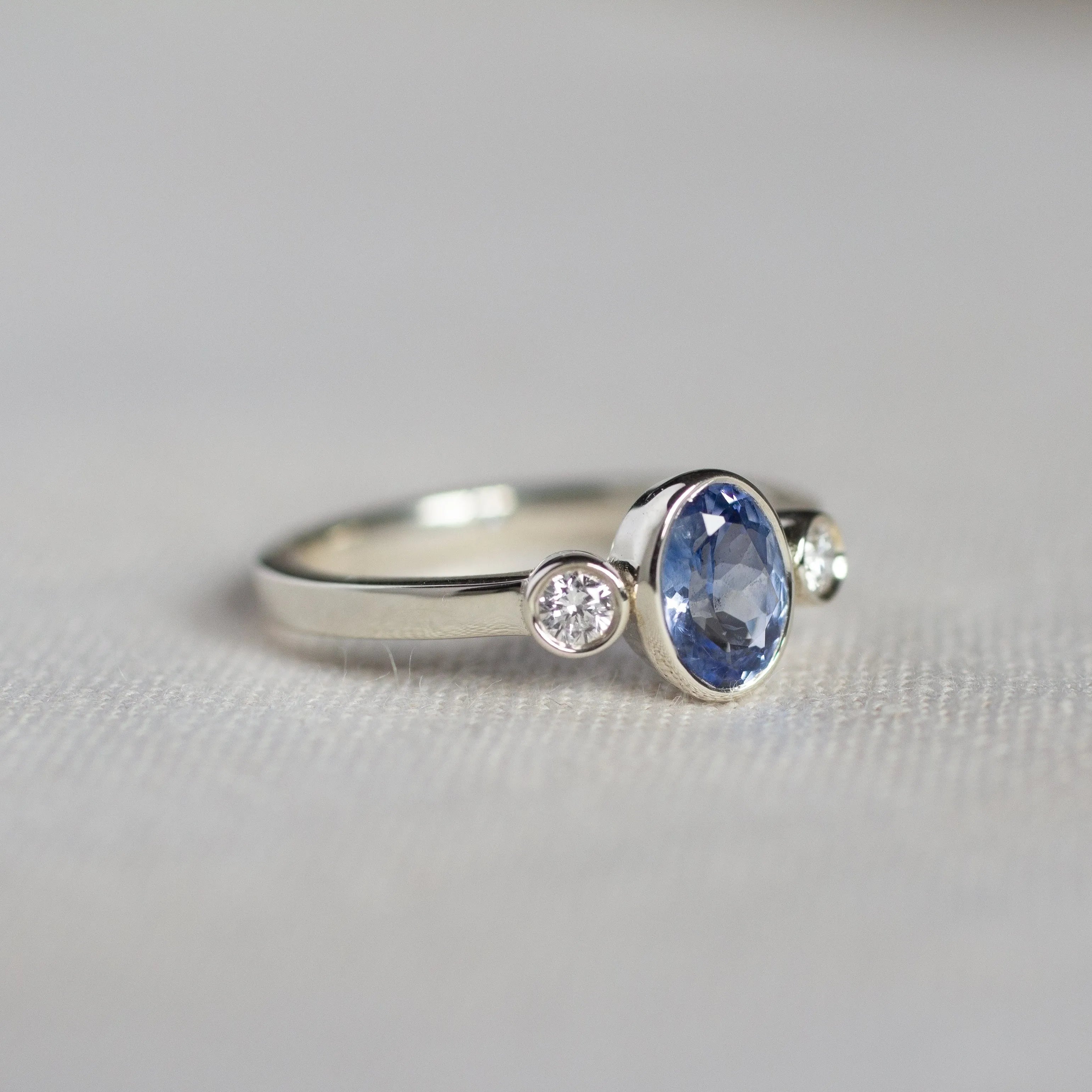 White Gold Bezel Set Blue Sapphire Engagement Ring with Round Diamonds