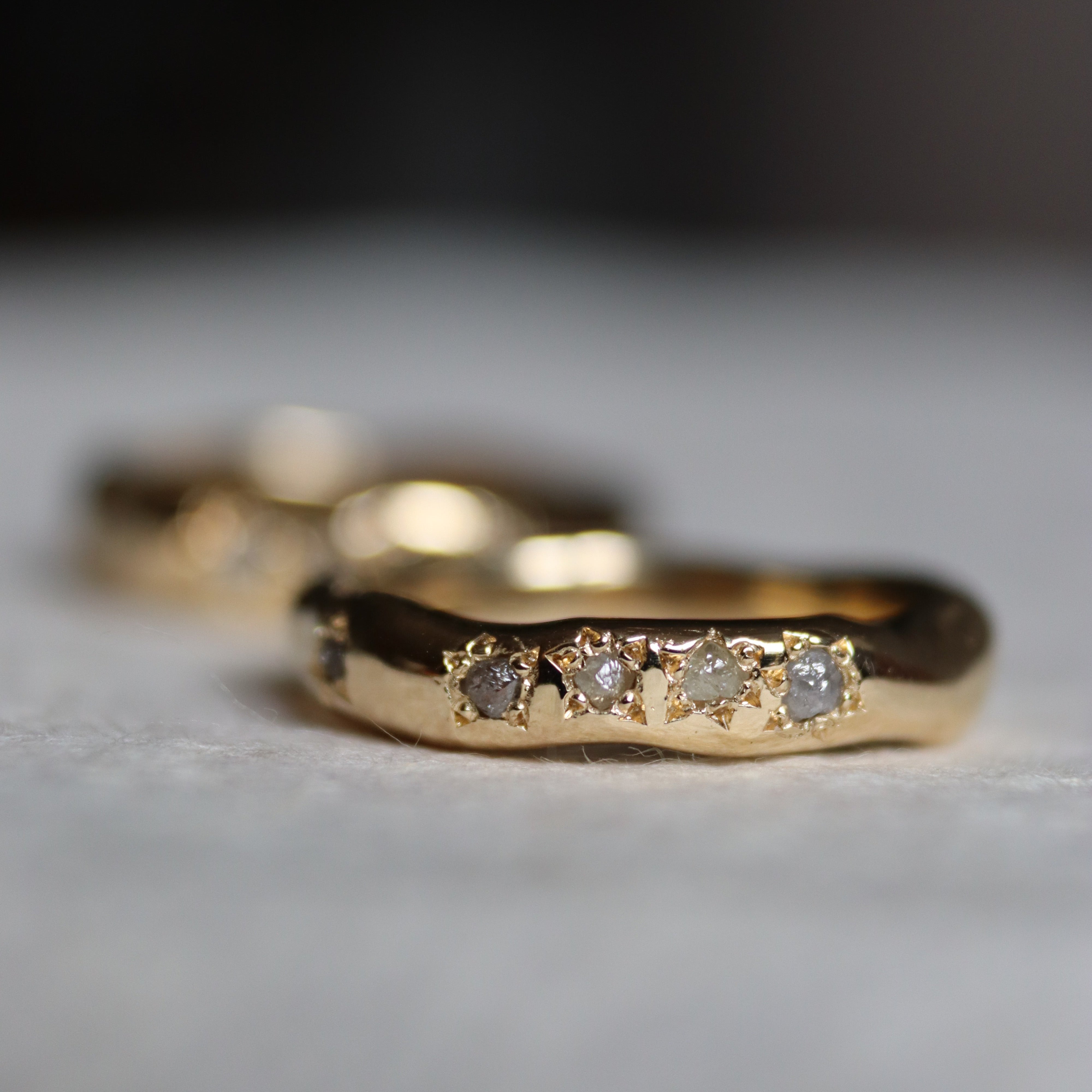 bespoke gold ring with four stones in star shaped bezel settings