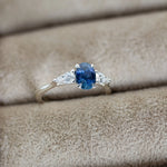 Silver ring with a blue gemstone on beige fabric