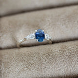Silver ring with a blue gemstone on beige fabric