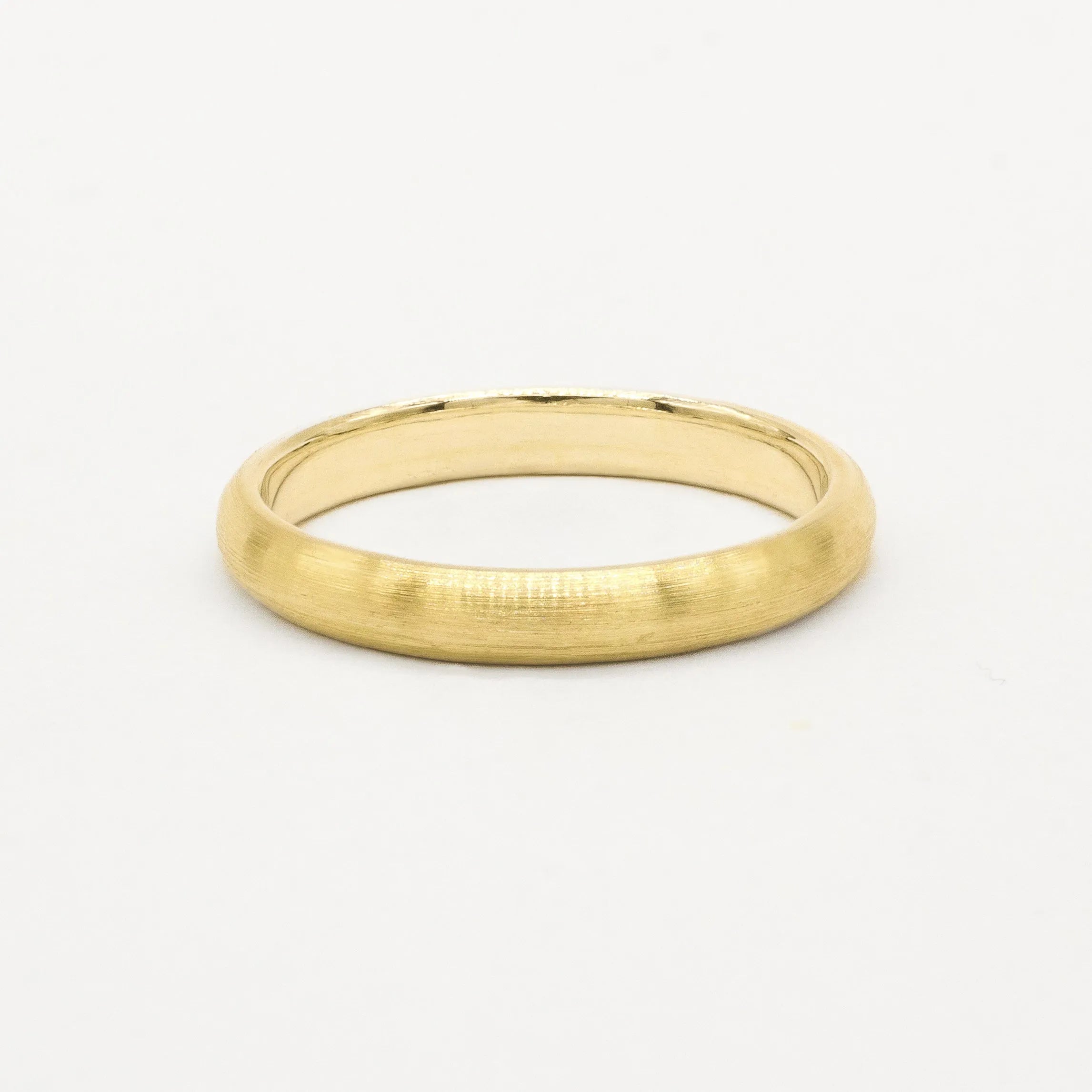 Gold 3mm brushed wedding ring on a white background