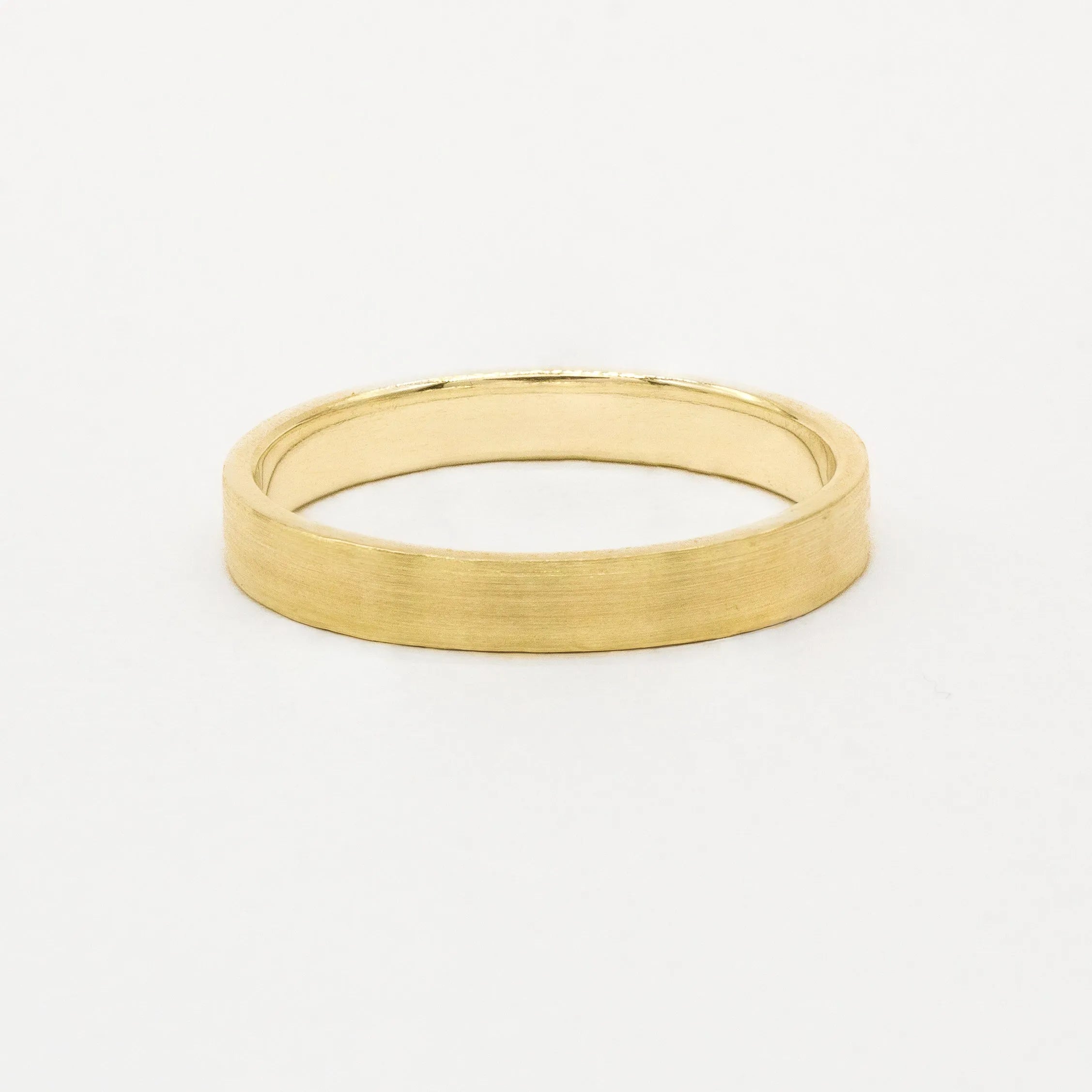 Gold brushed wedding ring in flat shape on a white background