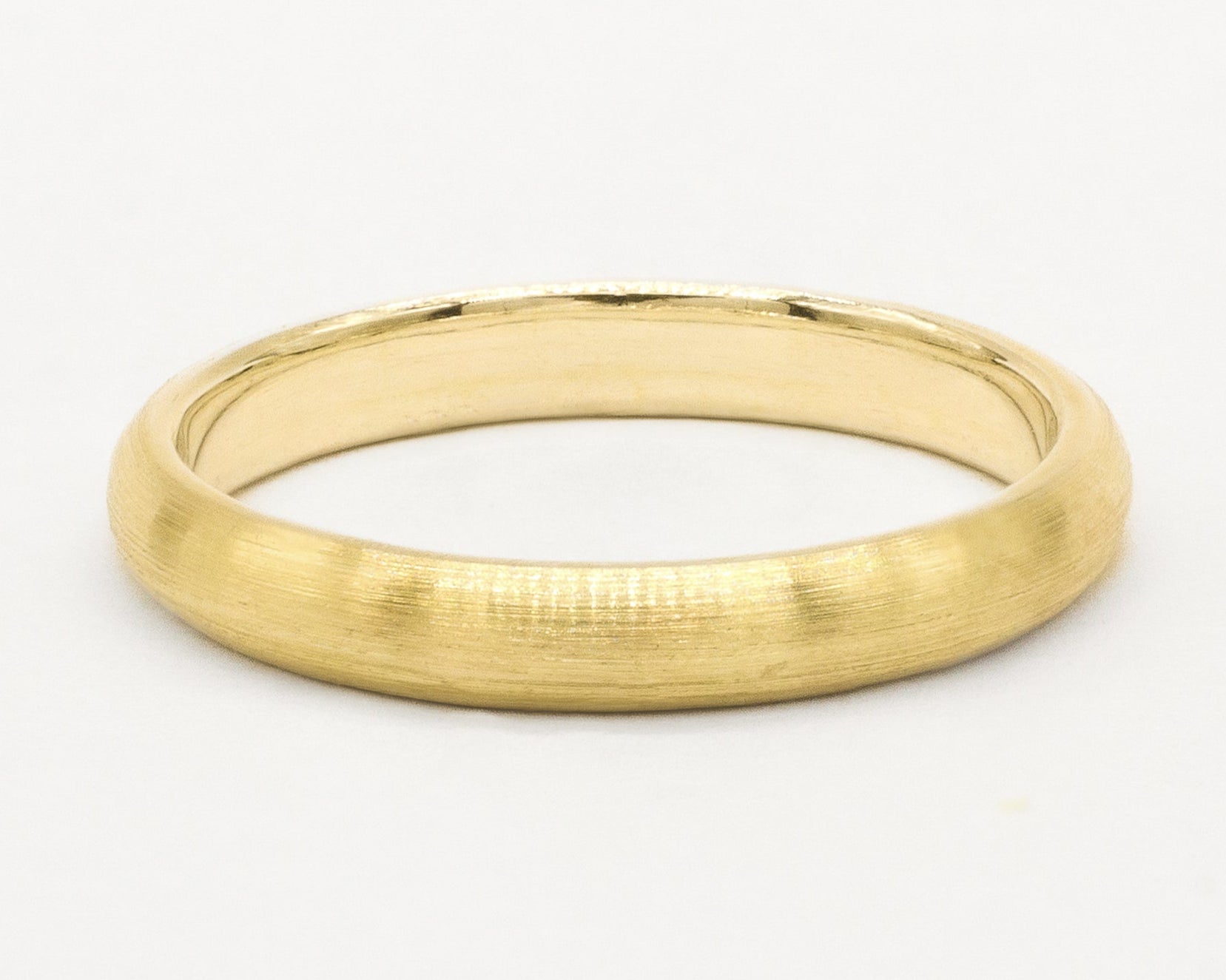 Gold brushed wedding ring on a white background