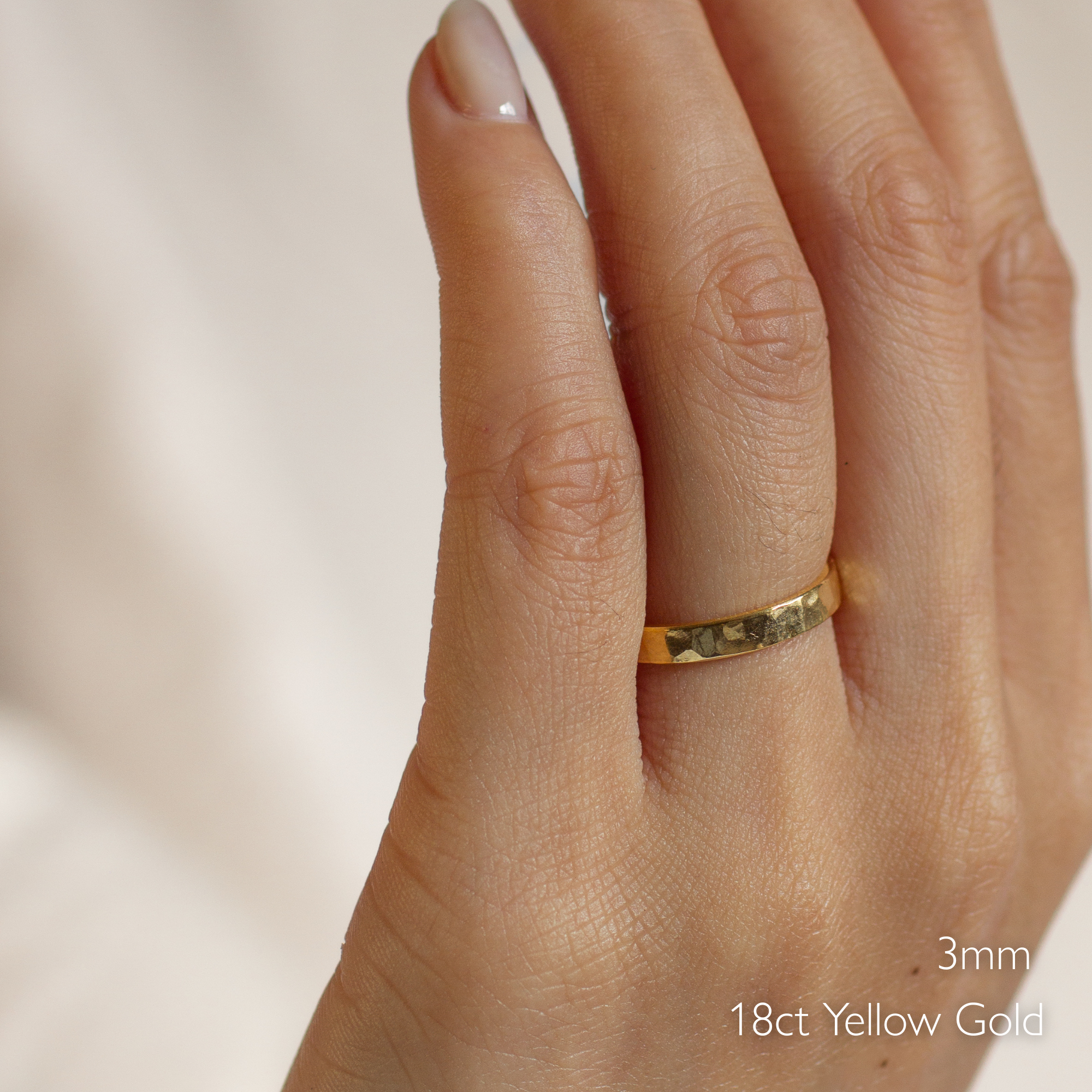 Gold ring  with chunky hammered finish on a hand with '18ct Yellow Gold' and '3mm' text.
