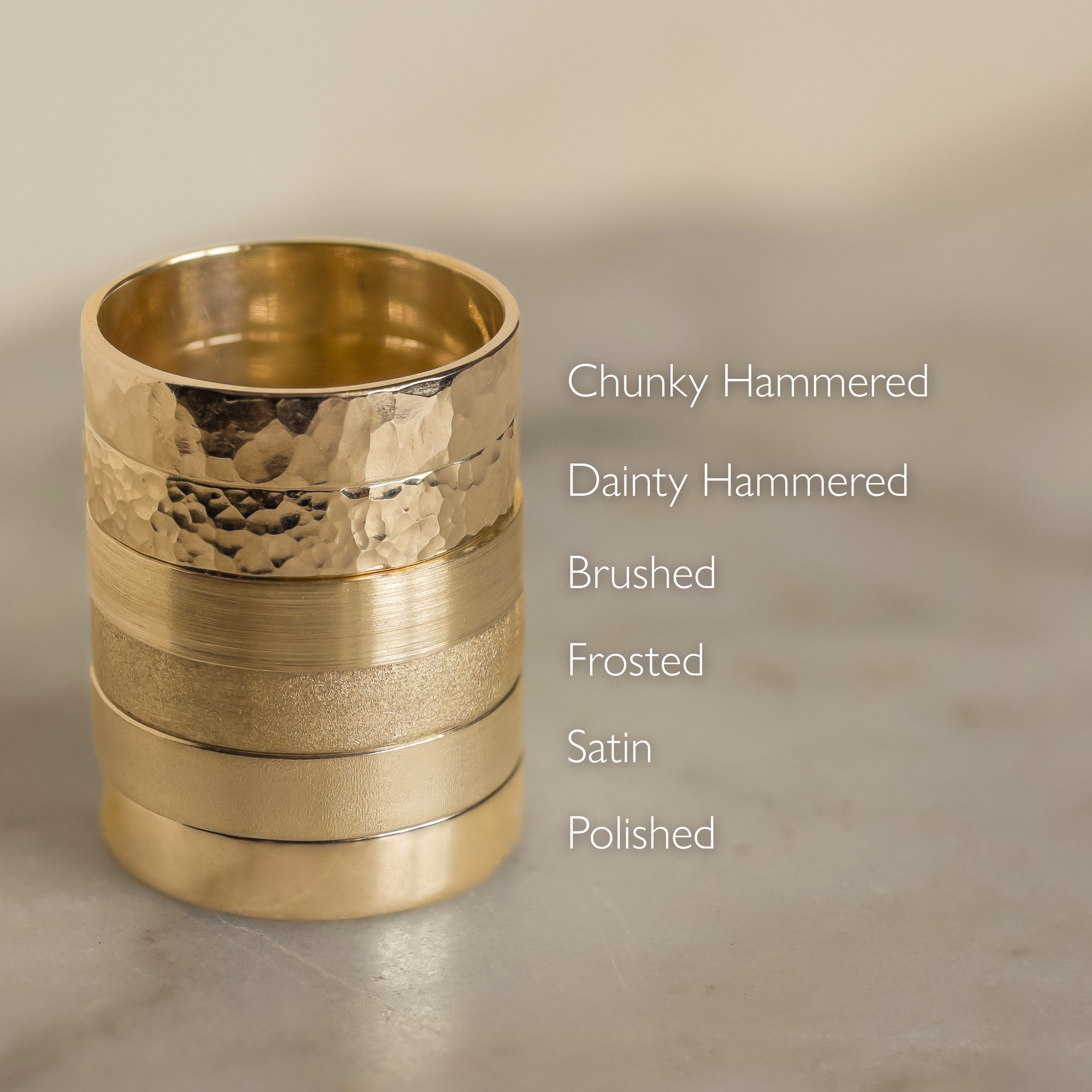 tower of 6 gold flat wedding rings in different texture finishes