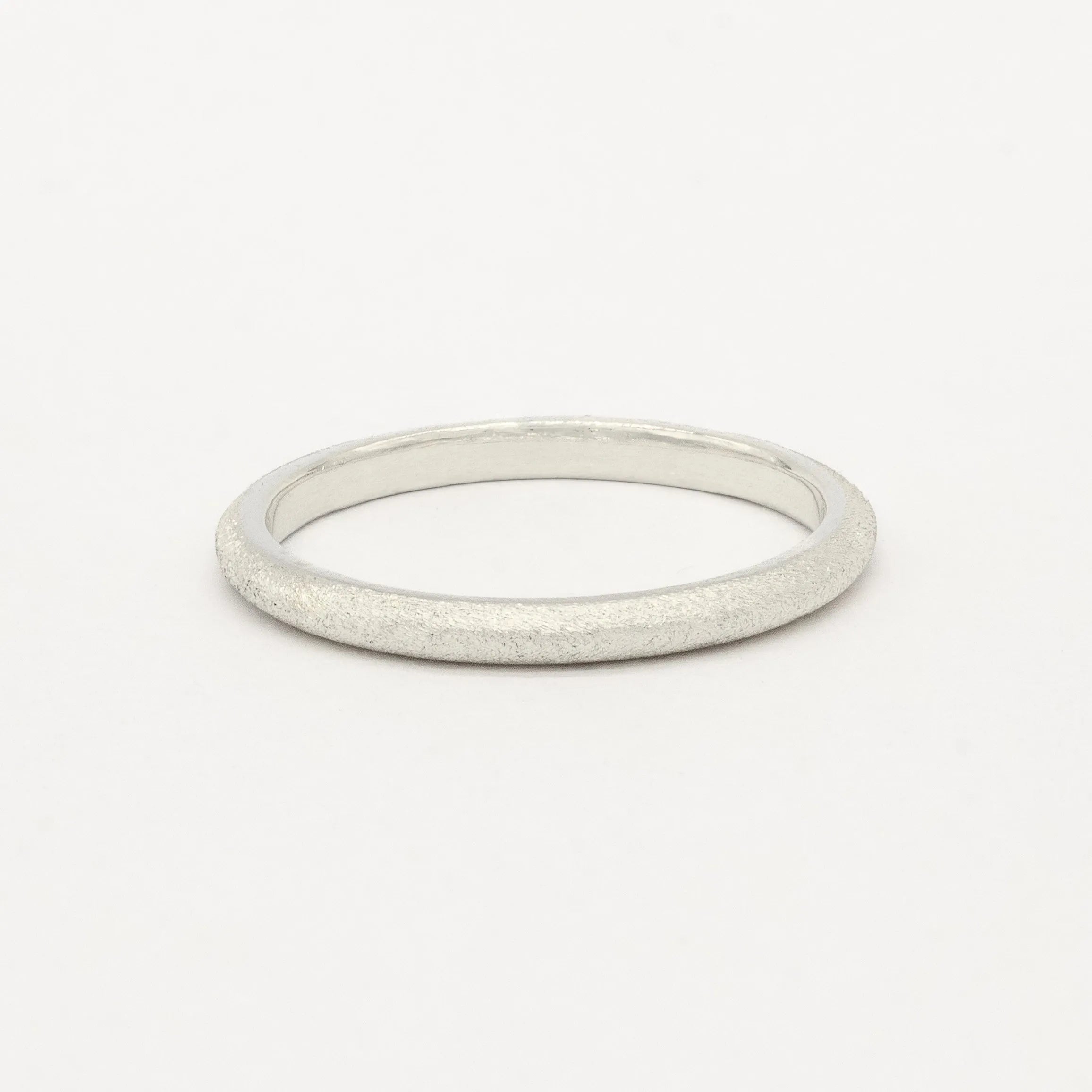 2mm wide slmi white gold frosted ring on a light gray background