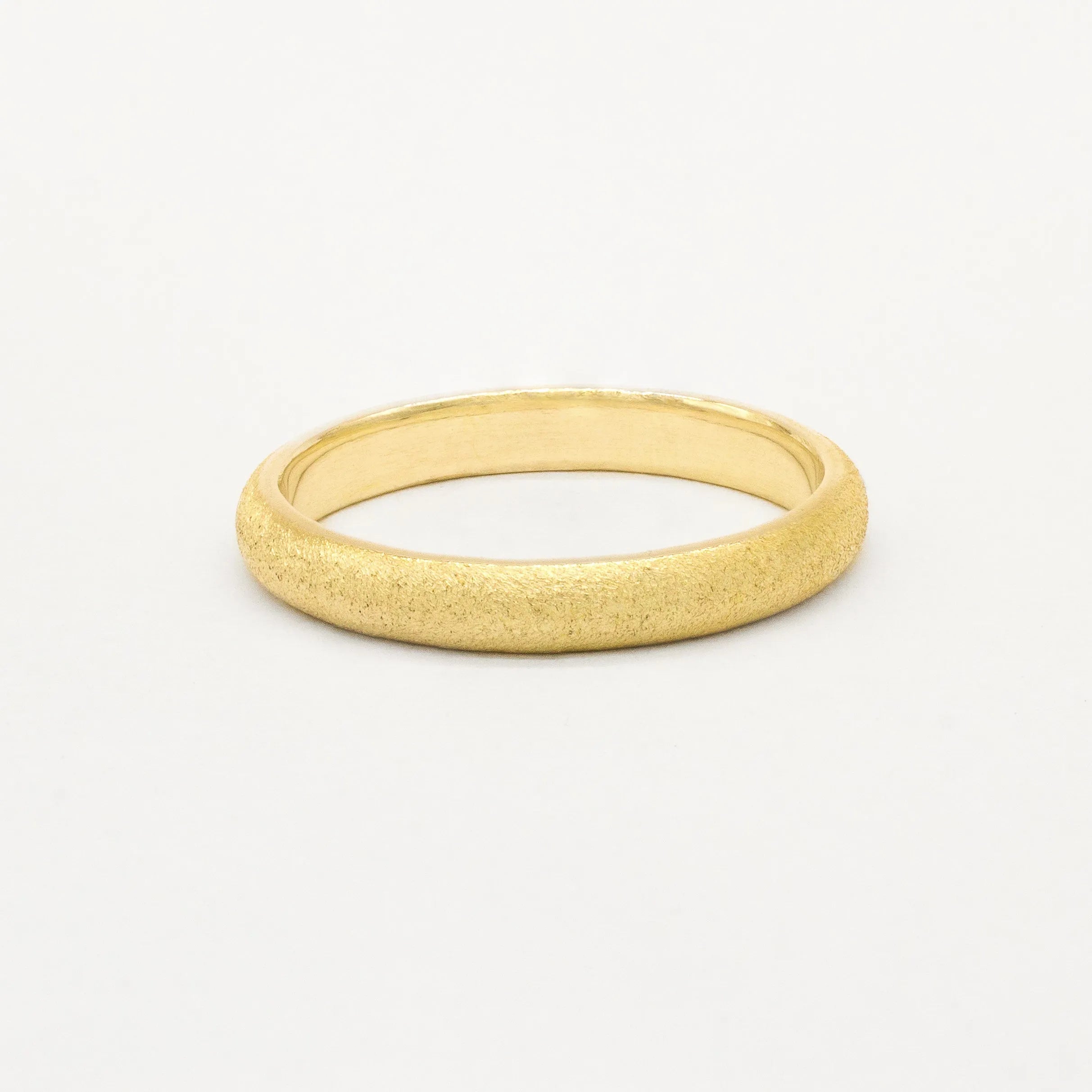 Gold frosted wedding ring on a white background