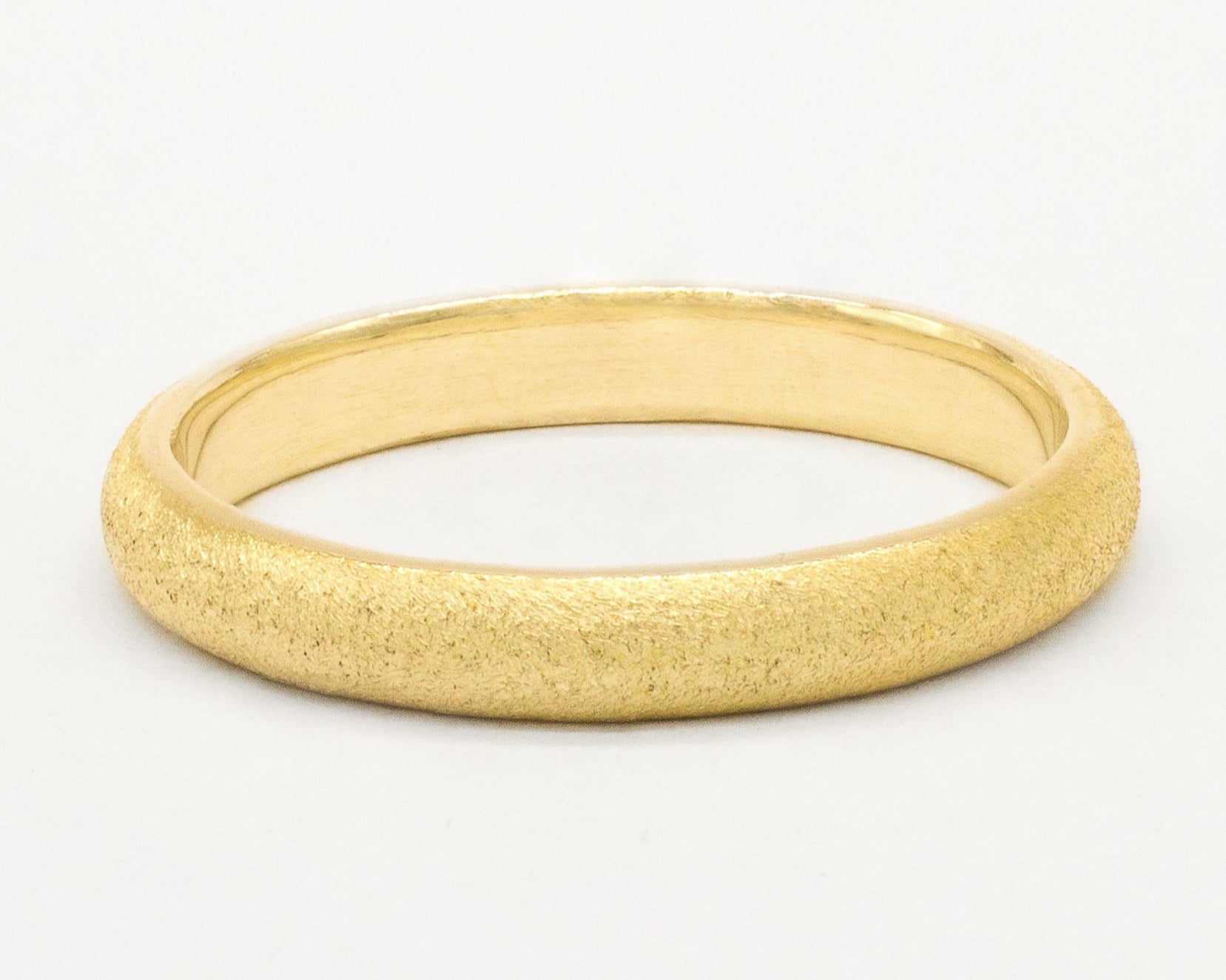 frosted wedding ring in gold on white background