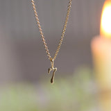 gold 7 number necklace with blurred background and candle