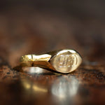 gold ancient pinkie signet ring with the letters g, b and d engraved in uppercase